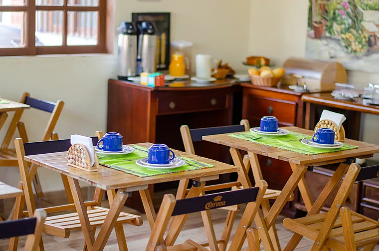 Mesa posta do café da manhã da Petit Refuge com xícaras azuis e talheres