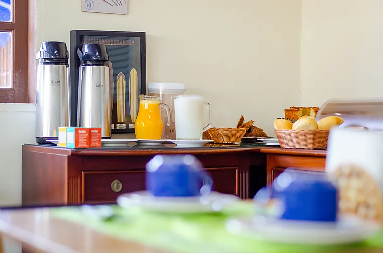 Garrafas de café e leite, jarra de suco de laranja e leite no café da manhã da Petit Refuge