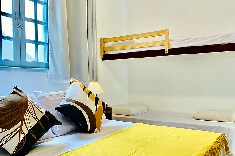 Cama de casal da Família Superior da Petit Refuge com a cama alta ao fundo