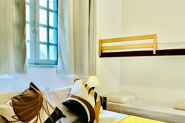 Cama alta com grade de madeira e cama baixa na Família Superior da Petit Refuge